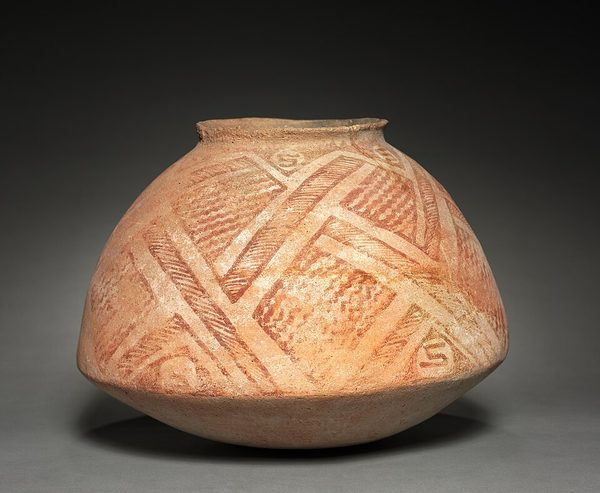 A wide round buff-coloured pottery jar painted with interlocking red bands