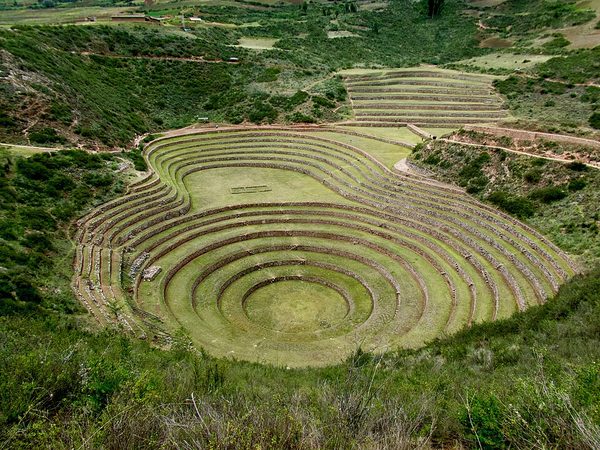 Concentric rings of stone-walled terraces cut down into a natural bowl in the ground
