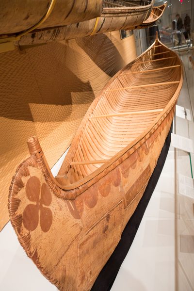 A birchbark canoe with a decorated prow, on museum display