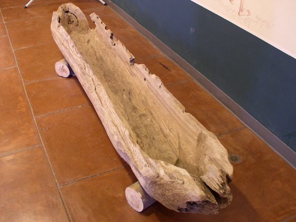 A canoe carved from a single log, on display in a museum